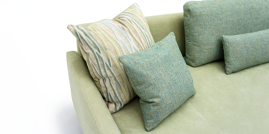 EASY - Detailbild vom Liegesofa in hellgrünen Alcantara mit grün melierten Zierkissen
