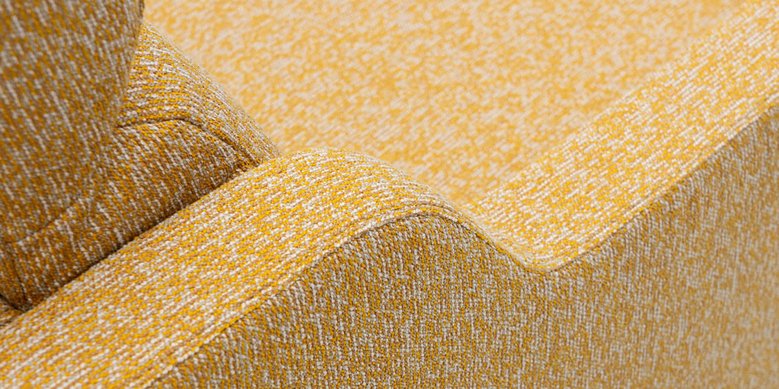 EVIA - Detailbild der geschwungenen Armlehne in Stoff Höpke Paradiso Fares gelb meliert