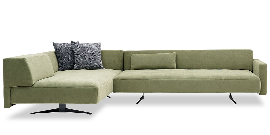WAVE - Ecksofa mit Kufen in grünem Stoff Mousse mit passenden Sofakissen