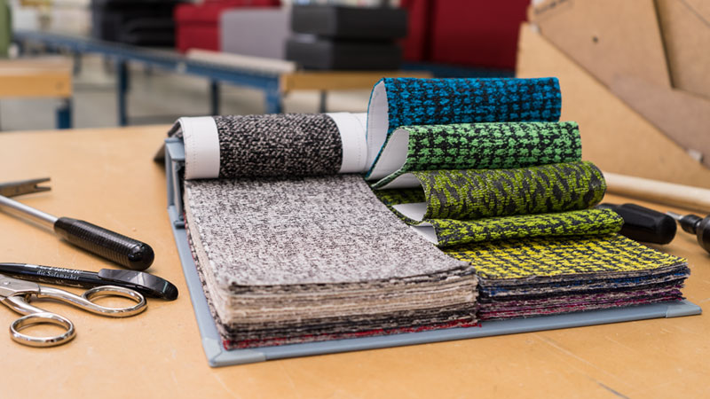 Bild der Stoffkollektion Mavone mit Produktion im Hintergrund