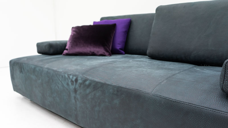 Detailbild von Sofa Astor in Leder Pamplona mit Deko- und Armlehnenkissen