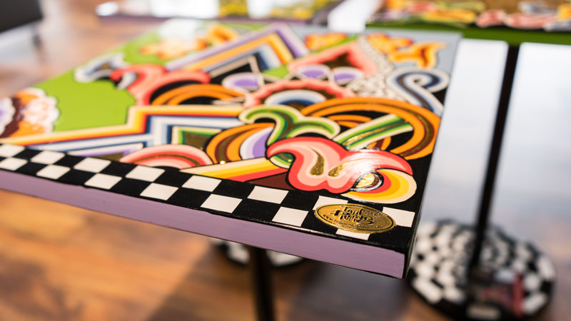 original Toms Drag Logo auf handbemaltem Tisch