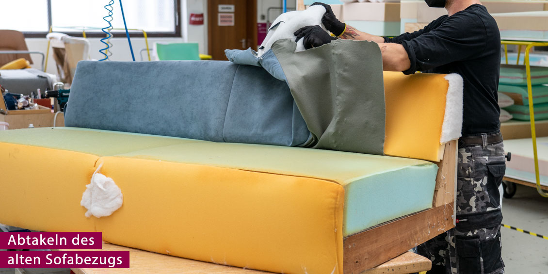 Polsterer takelt den alten Sofabezug ab