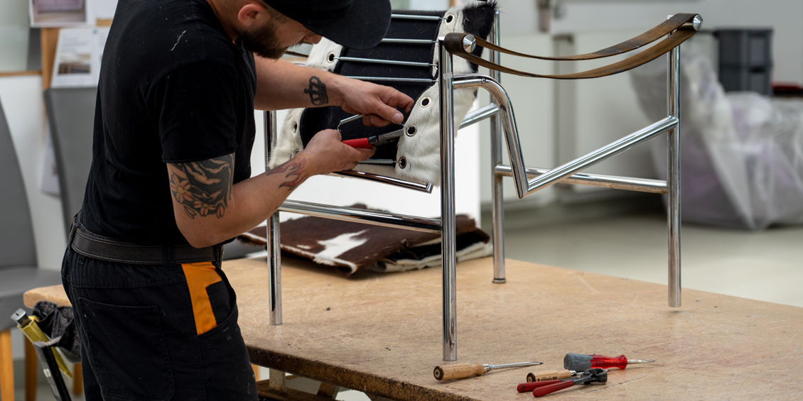 Polsterer spannt neue Federn beim alten Designer-Sessels von Cassina Modell LC1