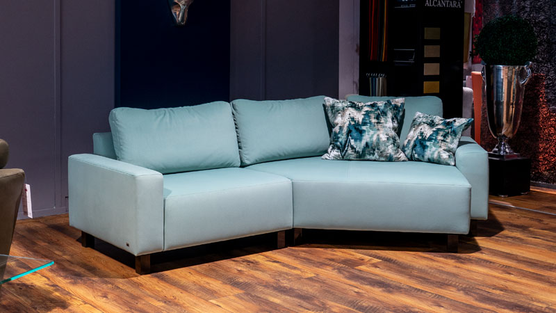 Sofa Delta ist bezogen im hellblauen Stoff Fellow und steht in unserem Showroom zum Probesitzen bereit