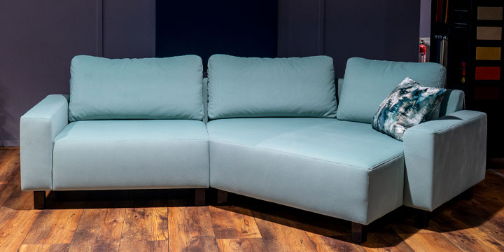 Modell Indigo mit Delta - ein Ecksofa in Trepezform - ist bezogen im pastellblauen samtweichen Stoff Fellow Woolly